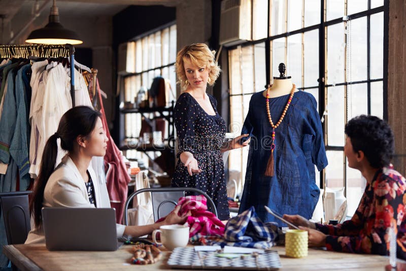 Three Fashion Designers In Meeting Discussing Garment