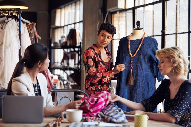 Three Fashion Designers In Meeting Discussing Garment