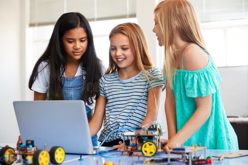 Three Female Students Building And Programing Robot Vehicle In After School Computer Coding Class royalty free stock photos