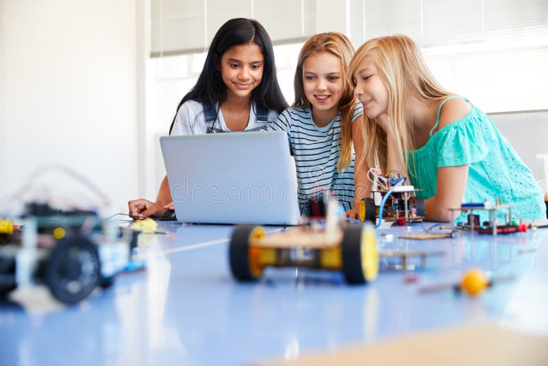 Three Female Students Building And Programing Robot Vehicle In After School Computer Coding Class royalty free stock images