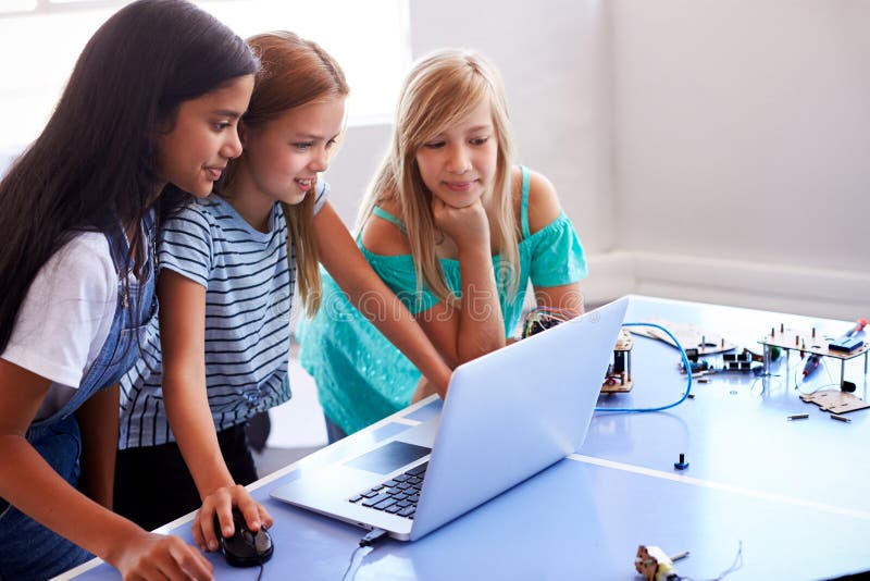 Three Female Students Building And Programing Robot Vehicle In After School Computer Coding Class royalty free stock photo