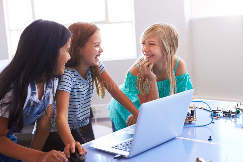 Three Female Students Building And Programing Robot Vehicle In After School Computer Coding Class royalty free stock images