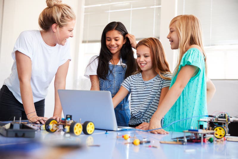 Three Female Students With Teacher Building Robot Vehicle In After School Computer Coding Class royalty free stock images