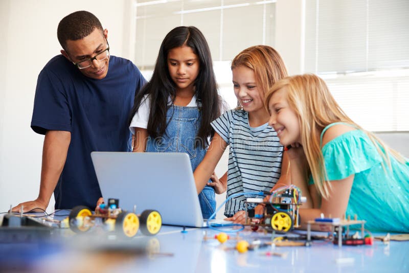 Three Female Students With Teacher Building Robot Vehicle In After School Computer Coding Class royalty free stock photos