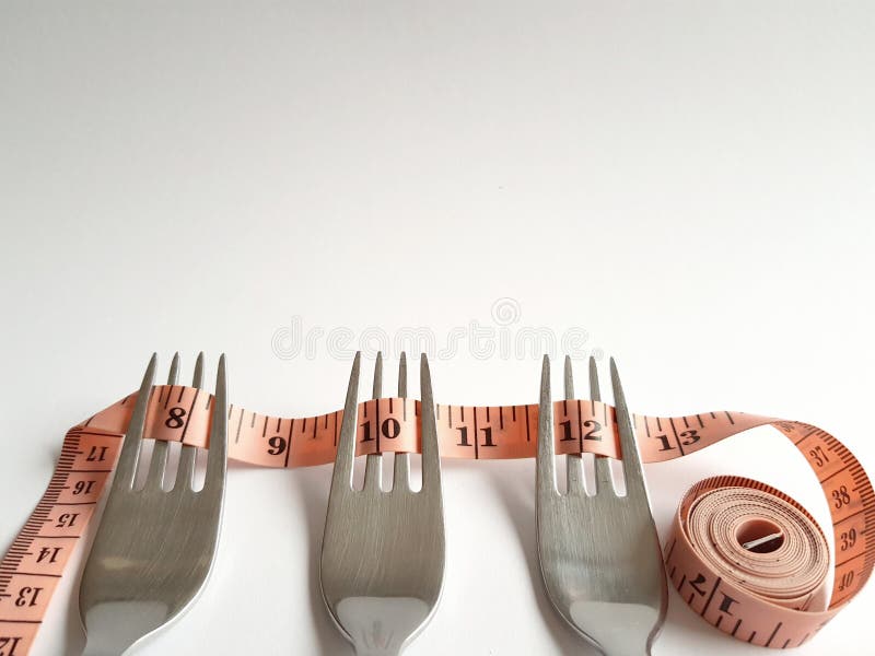 Three forks with a mesuring tape rolled on them stock image Three forks with a mesuring tape rolled on them stock image