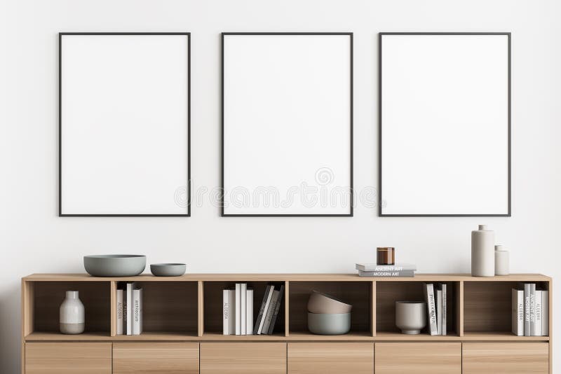 Three framed posters on a light beige wall of a living room