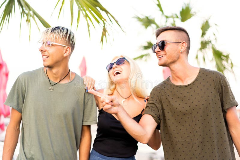 three friends cheerful company rest on a tropical beach and drink cocktails, very, magazine concept stock image three friends cheerful company rest on a tropical beach and drink cocktails, very, magazine concept stock image