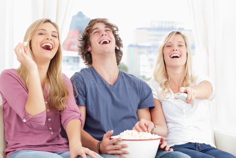 Three Friends Eating Popcorn while Laughing Stock Photo Image of
