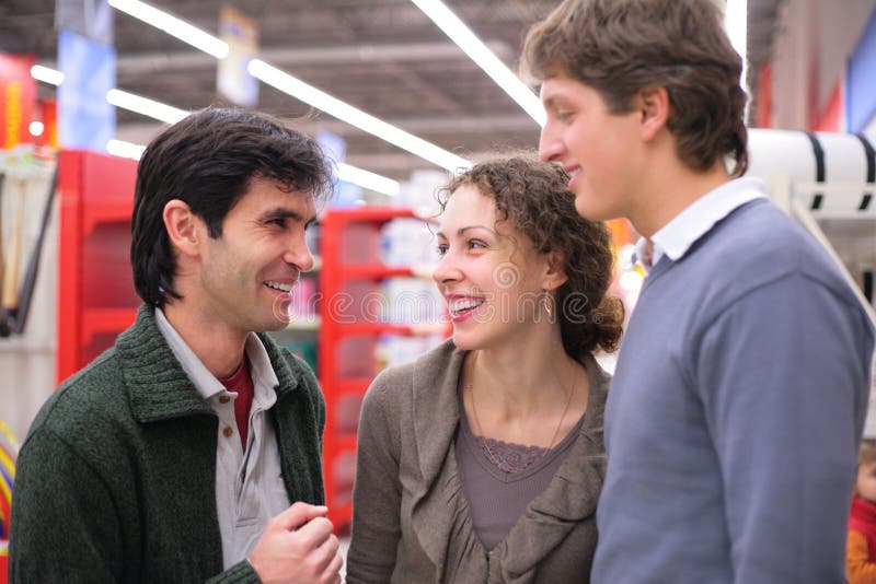 Three friends talk in shop