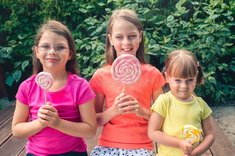 Three Funny Little Girls in Colorful T-shirts with Large Lollipops ...