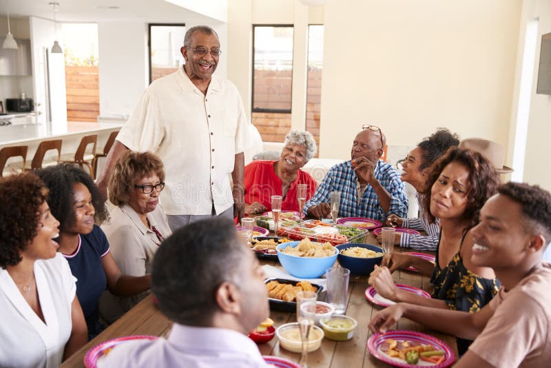 Three generation African American family sitting at dinner table celebrating together,close up stock images Three generation African American family sitting at dinner table celebrating together,close up stock images