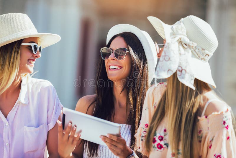 Three Girls with Colorful Shopping Bags Using Digital Tablet Stock ...