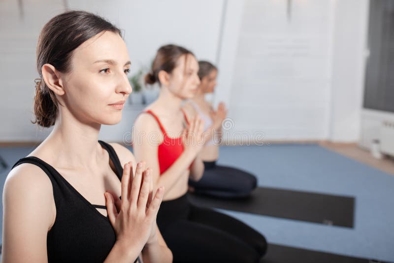 Three girls practicing yoga. Yoga instructor with her students