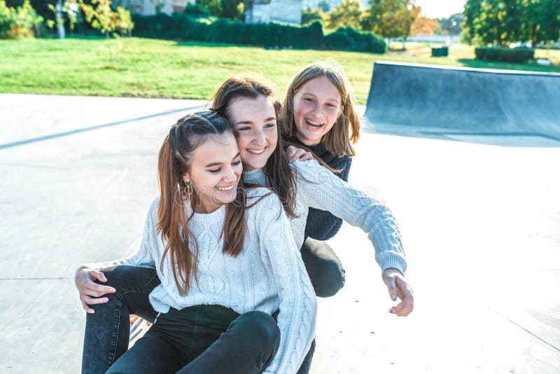 Three Funny Street Style Hipster Girls Posing At White Brick Wall