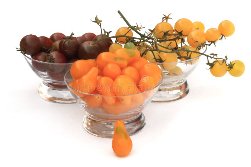 Three glass bowls filled with cherry tomatoes three different types. Horizontal image