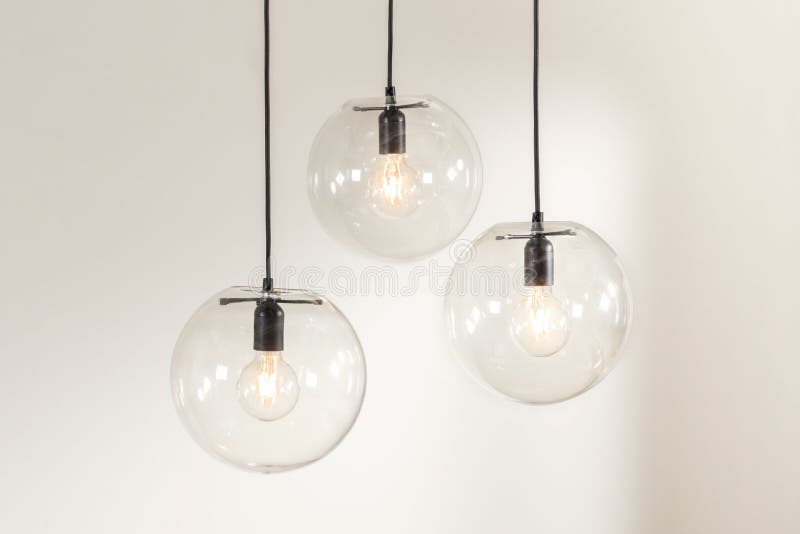 3 glass hanging light fixture with hanging bulbs on top of them