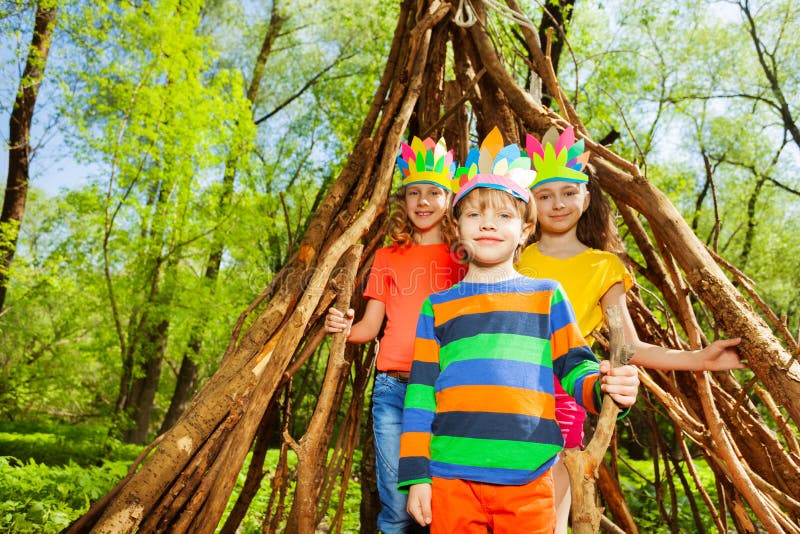 Three happy kids playing Injuns in the forest