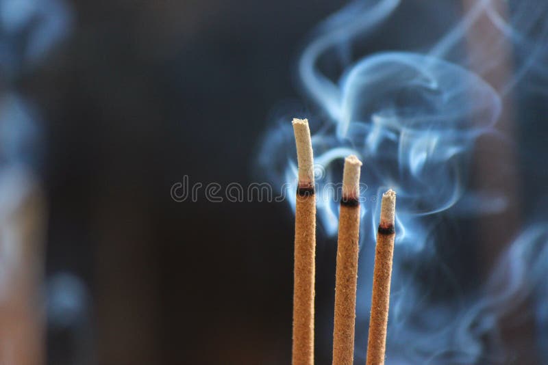 Smouldering incense sticks, burning and smoking