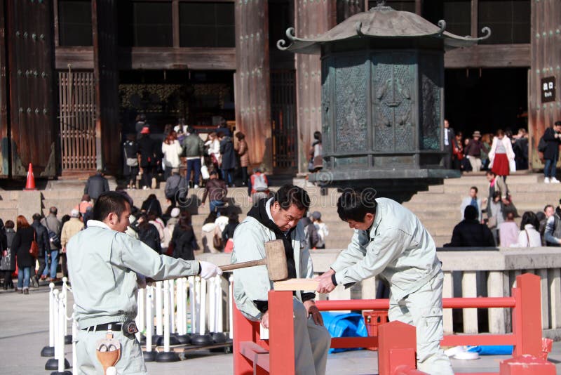 Three Japanese carpenter are construction the stage, Using a wooden hammer strike to the components of the stage. royalty free stock image