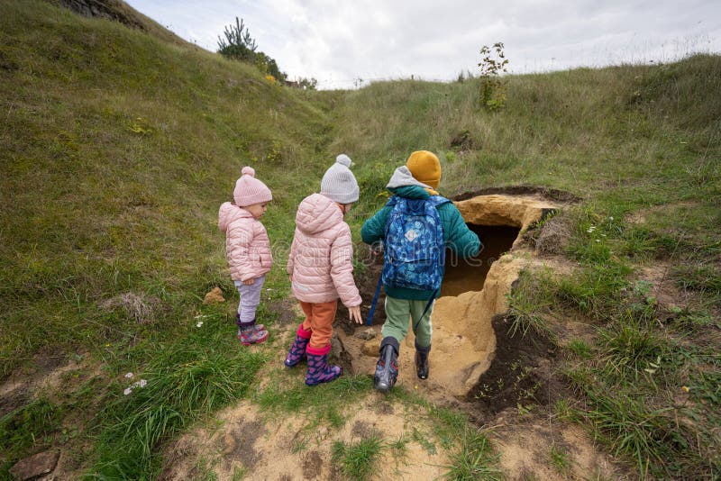 Three Kids Explore Limestone Stone Cave at Mountain Stock Image Image