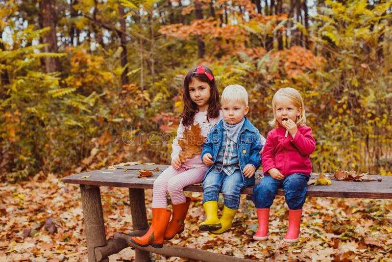 Three kids sitting on the bench and playing royalty free stock photo Three kids sitting on the bench and playing royalty free stock photo