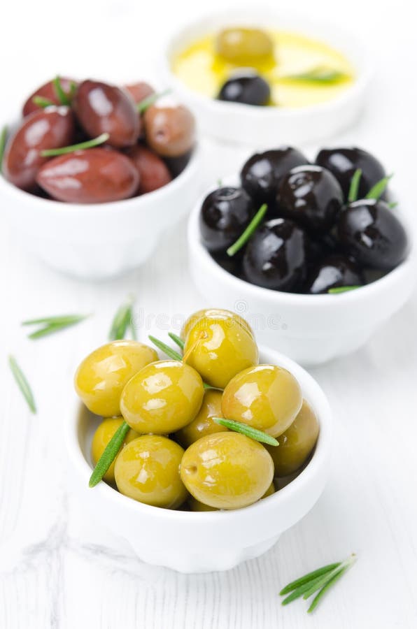 Three kinds of olives in bowls, fresh rosemary and olive oil stock image Three kinds of olives in bowls, fresh rosemary and olive oil stock image