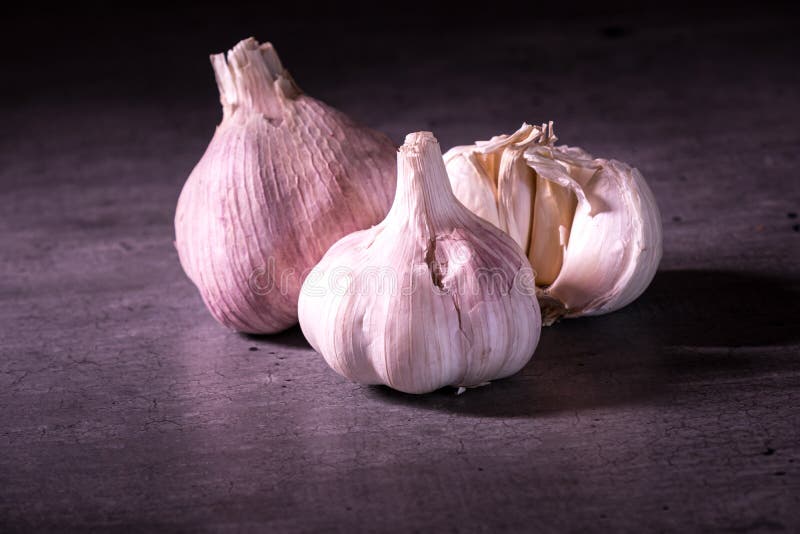 Three Large Heads of Pink Garlic on a Kitchen Worktop Stock Photo