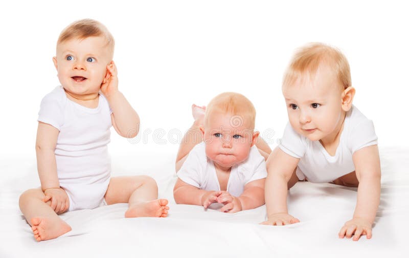 Three looking babies crawl and sit on blanket stock photos