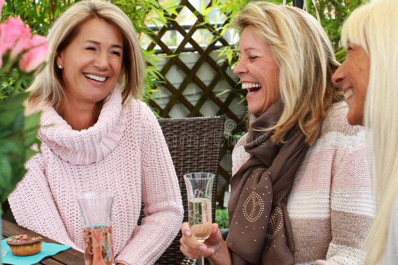 Three mature girlfriends toasting with glasses of sparkling wine