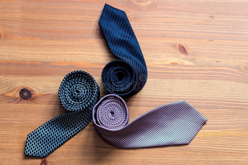 Three Men`s Tie Rolled into a Roll on a Wooden Background Stock Photo ...