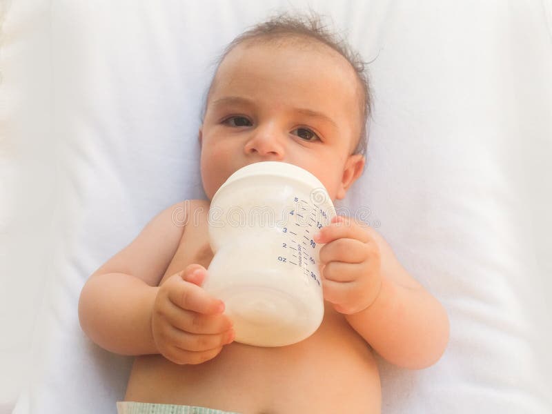 Three Months Old Baby Boy Drinking Milk from the Bottle Stock Photo