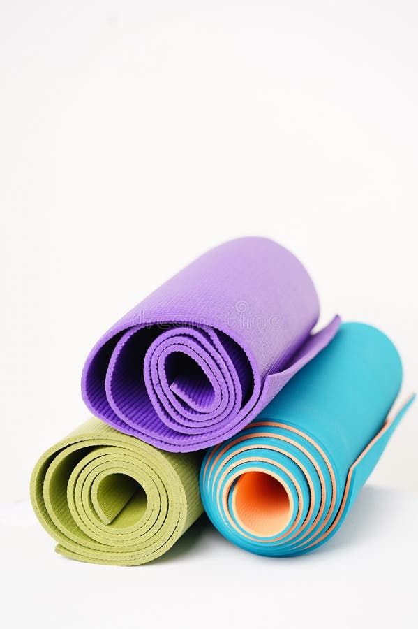 Three Multicolored Rolled Yoga Mats on a White Background Stock Image