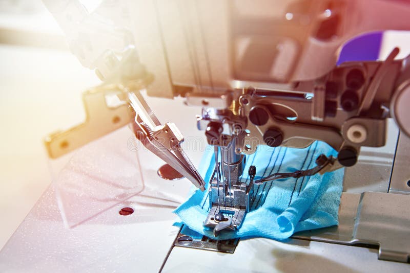 High-speed three-needle five-threaded industrial sewing machine of flat chain stitch with built-in servo and automatic thread trimming. Closeup machine tool stock images, royalty-free photos and pictures