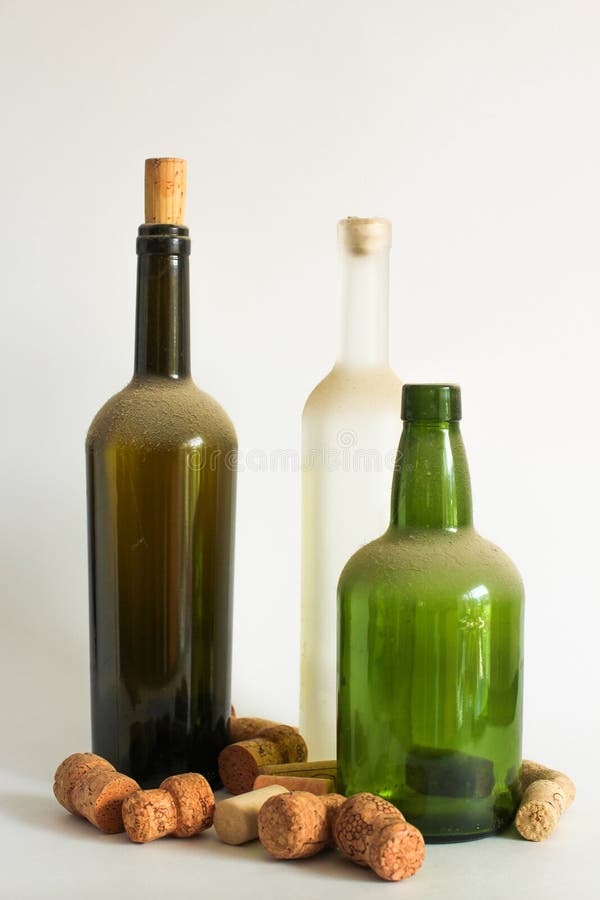 Three Old dust wine bottle and corks on white stock photo Three Old dust wine bottle and corks on white stock photo