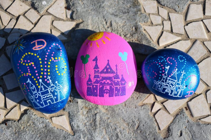 Three painted rocks resembling the castle at Disneyland