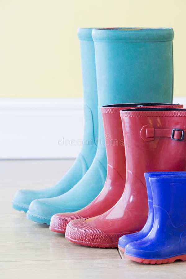 Three Pairs Of Colorful Gumboots In A Row.