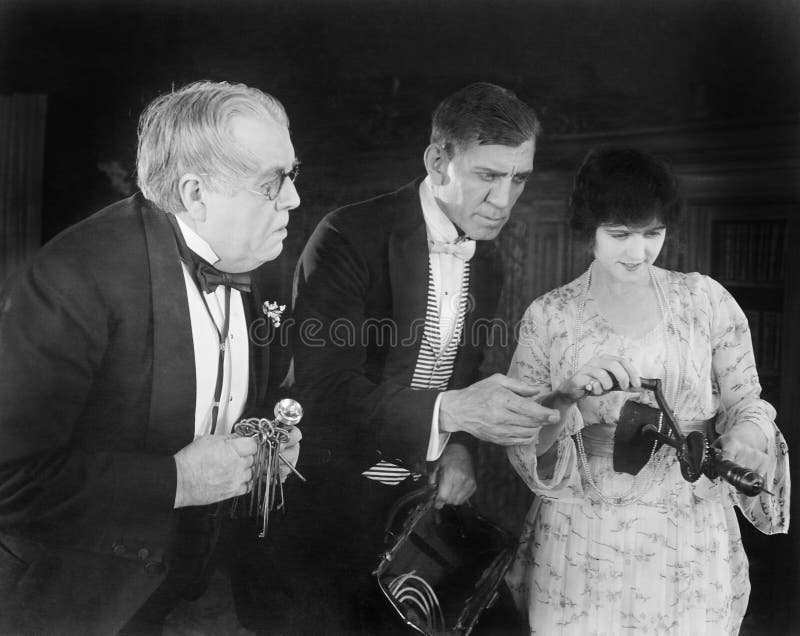 Three people checking out a manual drill stock photos