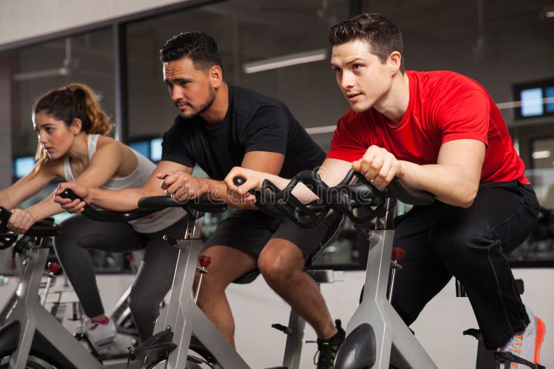 Three People Doing Cardio on a Bicycle Stock Photo Image of active