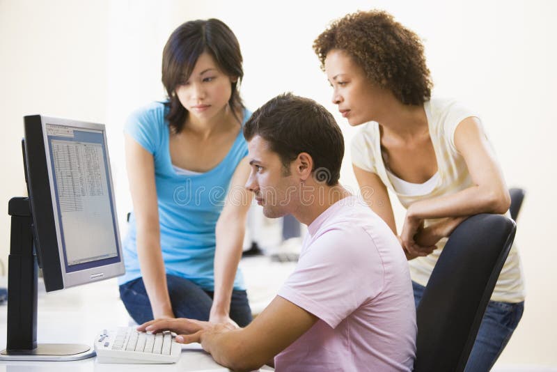 Three people sitting in computer room royalty free stock images