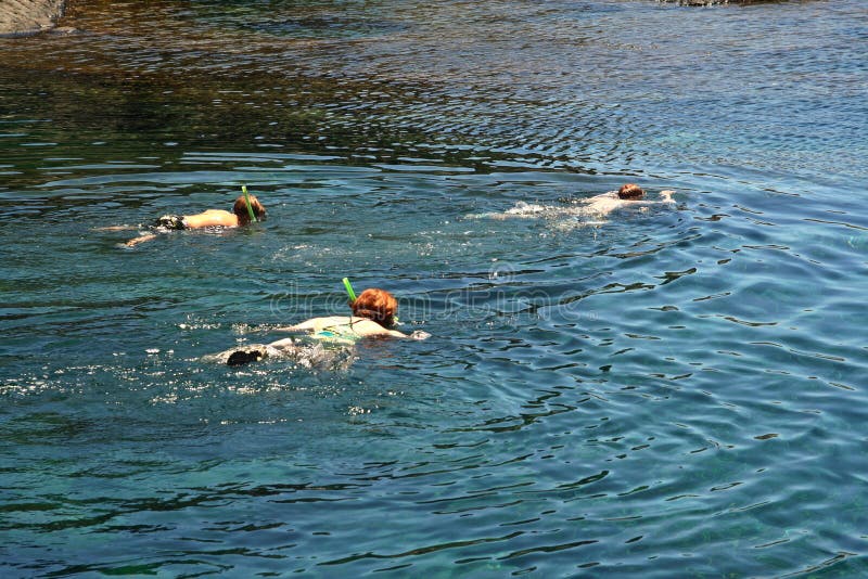 Three people snorkeling in a natural basin in Lanzarote