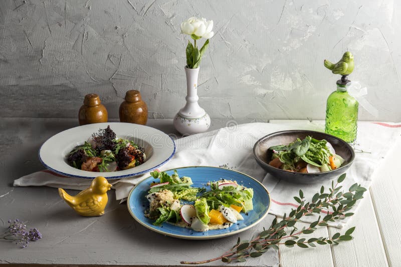 Three Plates Set of Green Healthy Salad on White Table Restaurant Menu