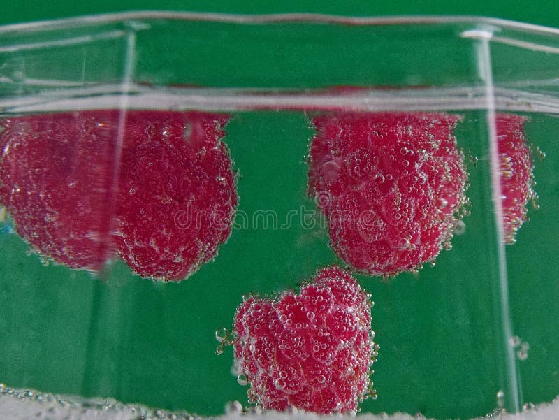Three raspberry berries in soda water close up royalty free stock photo Three raspberry berries in soda water close up royalty free stock photo