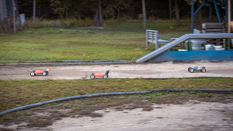 Tri RC buginy pretekajú na vonkajšej offroadovej dráhe