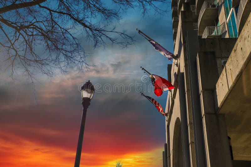 Three Red, White and Blue Flags Flying on a Concrete Hotel with a Tall