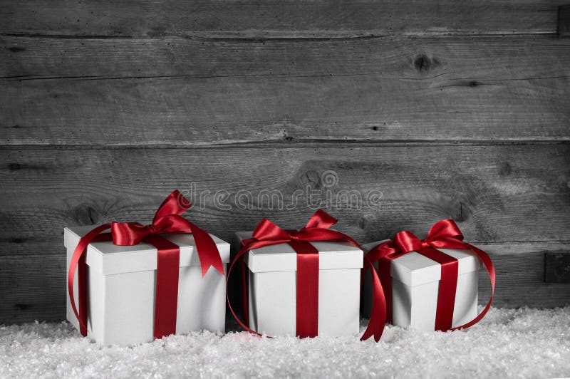 Three red white christmas presents on old wooden grey background