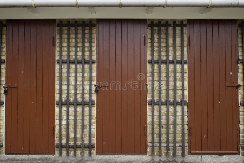 Three Red Wooden Doors in Yellow Brick Wall royalty free stock photos Three Red Wooden Doors in Yellow Brick Wall royalty free stock photos