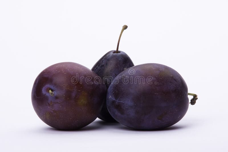 Three ripe plums on white background