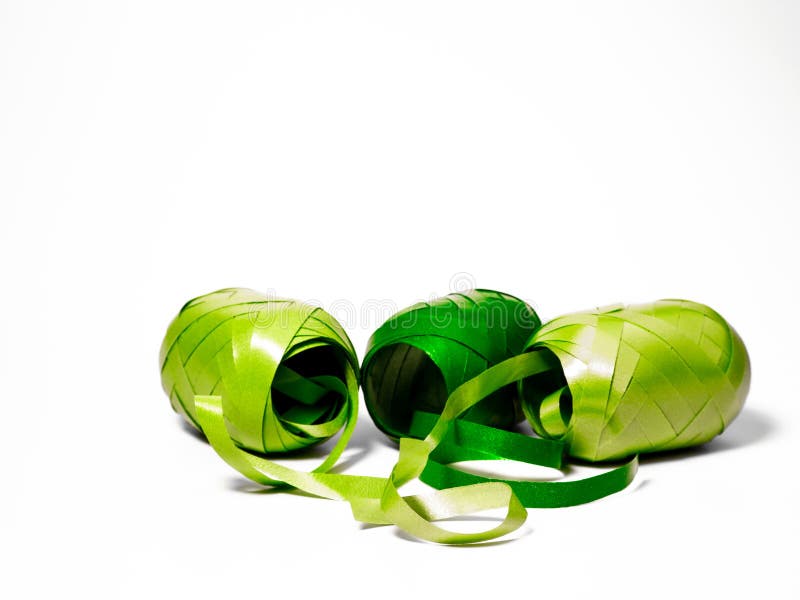Three Rolls of Ribbon in Different Green Colours in Front of a White