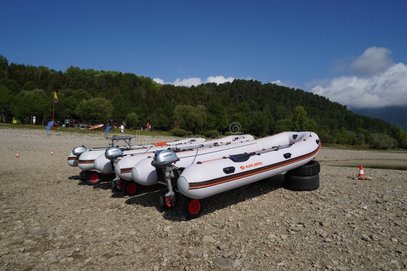 Three rubber dinghy or boats with overboard suspended motor.