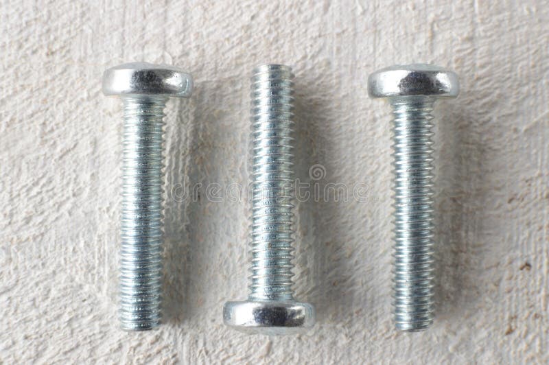 Three Screws on a White Wooden Table Stock Photo Image of steel